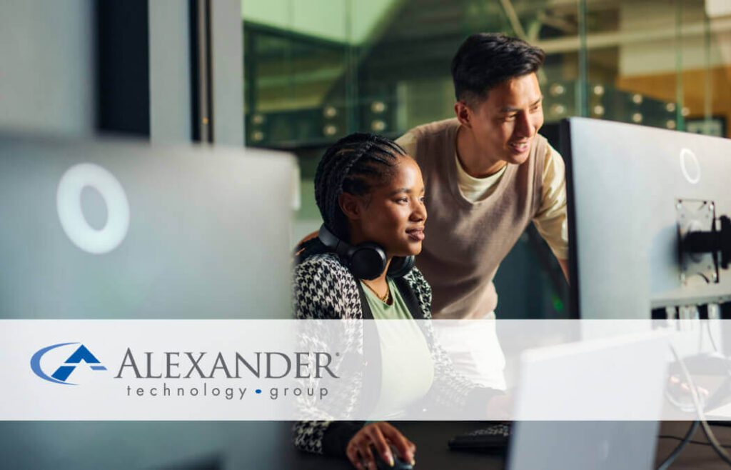 a man and a woman looking at computer monitor together