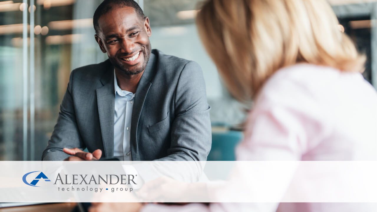 People sitting at a table smiling at each other in a conference room
